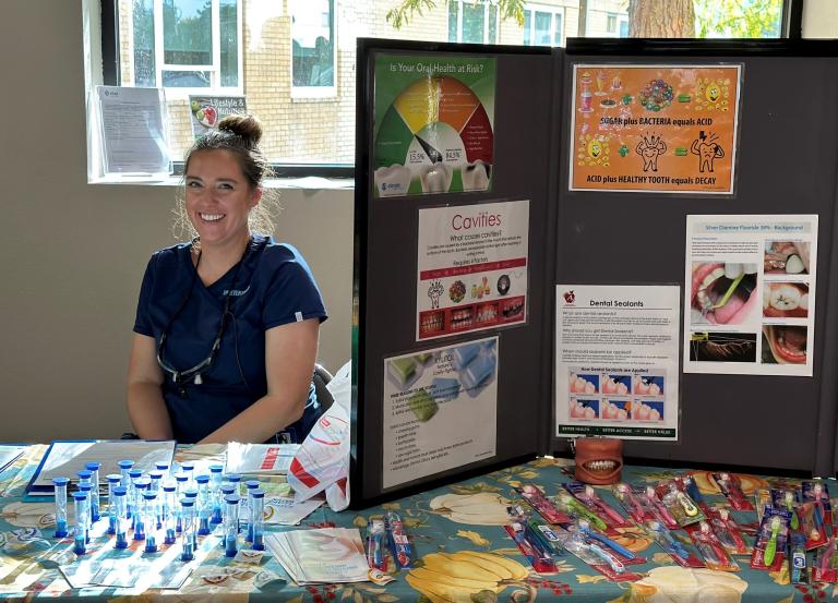 A member of the Advantage Dental Community Care Team presenting oral health educational materials for children.