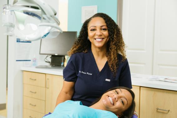 A dentist and patient smiling after completing a treatment plan.